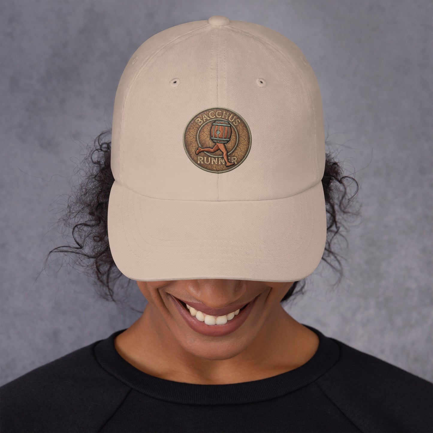 Person wearing a beige cap with "Bacchus Runner " text on a gray background