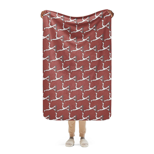 Person holding a red blanket with white Lux character pattern on a white background