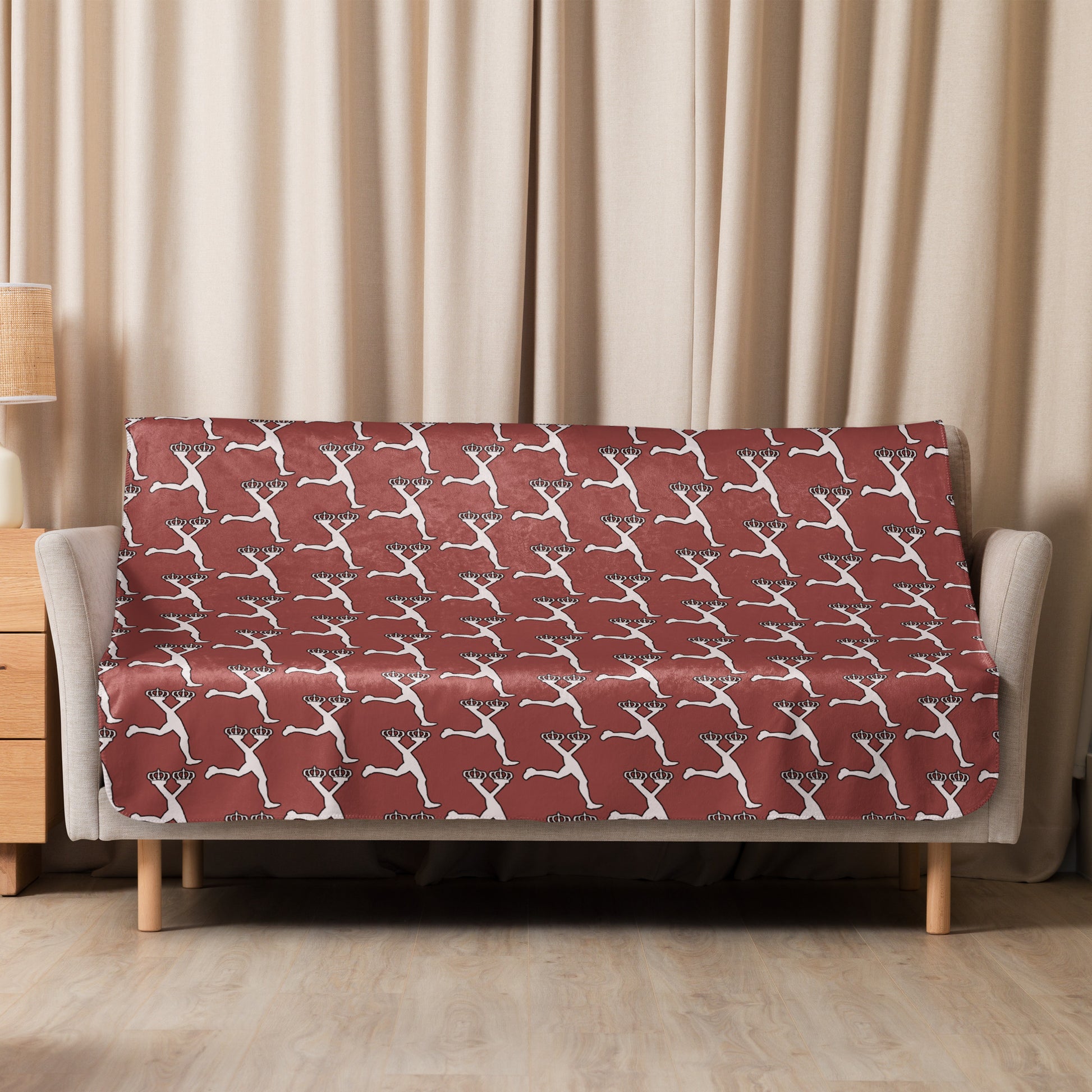 Sofa with a marron blanket patterned cover with Lux  in a living room setting.