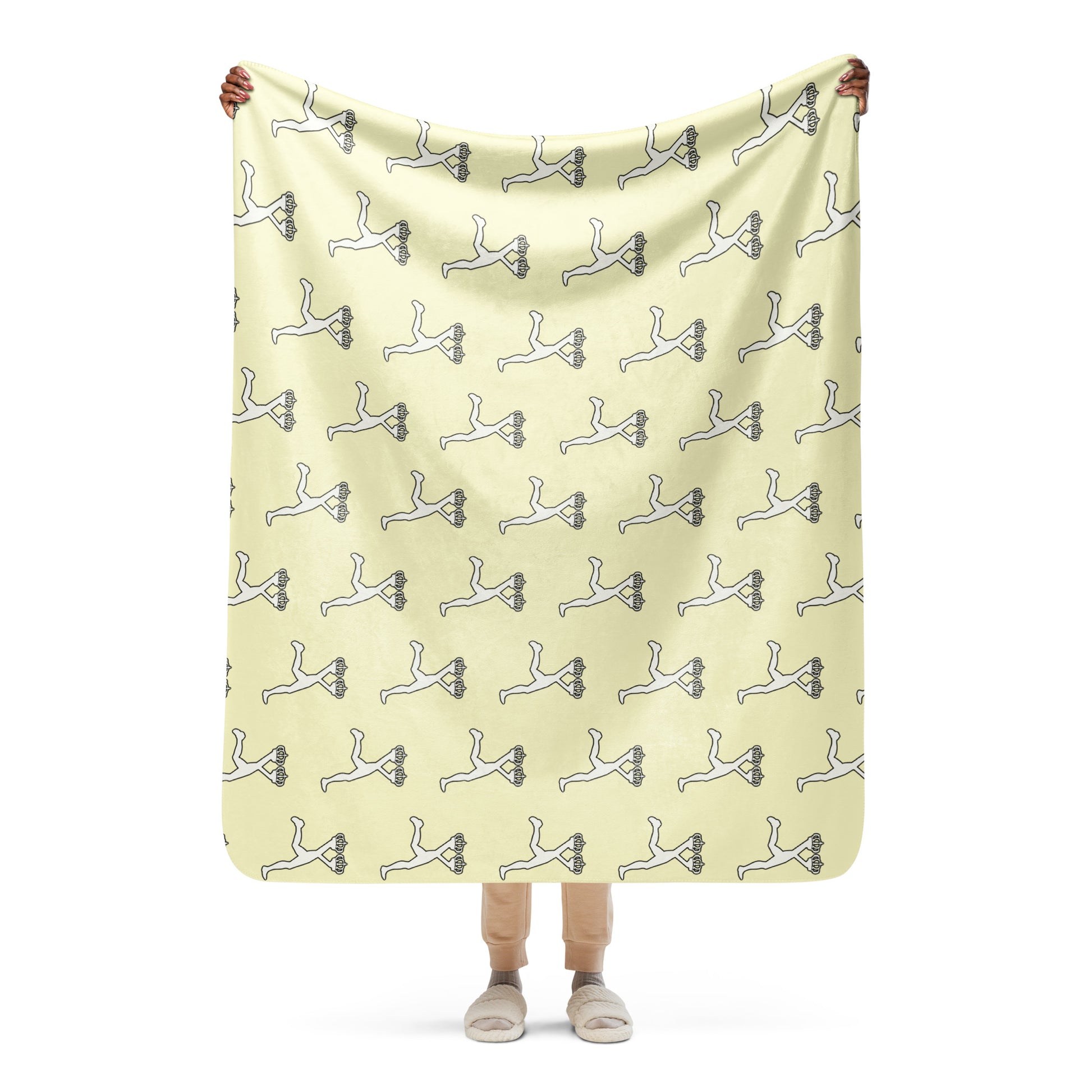 Person holding a large cream color blanket with the pattern of the character of Lux by Ciaoye