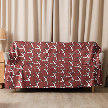 Sofa with a red and white patterned cover with Lux character against beige curtains.