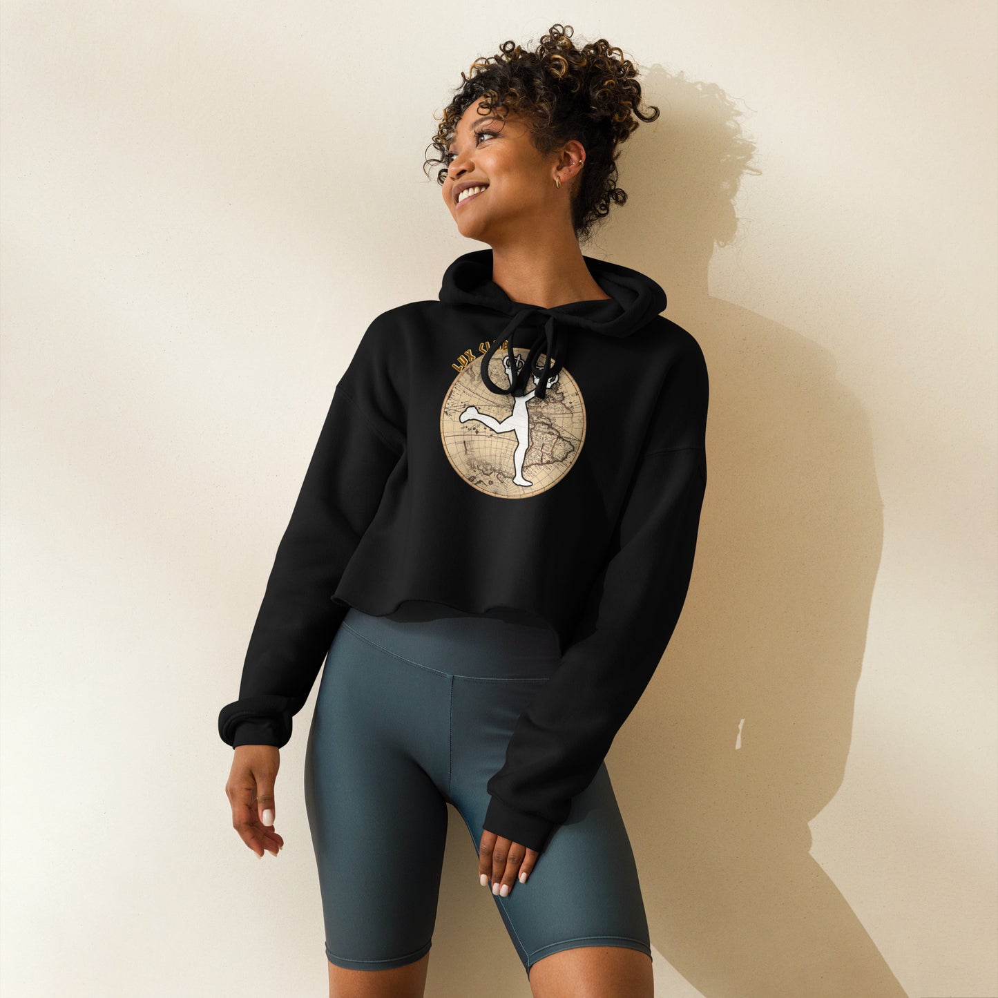 Woman wearing a black crop hoodie with long sleeves with a graphic design of a globe in front and the famous character of Lux in the center